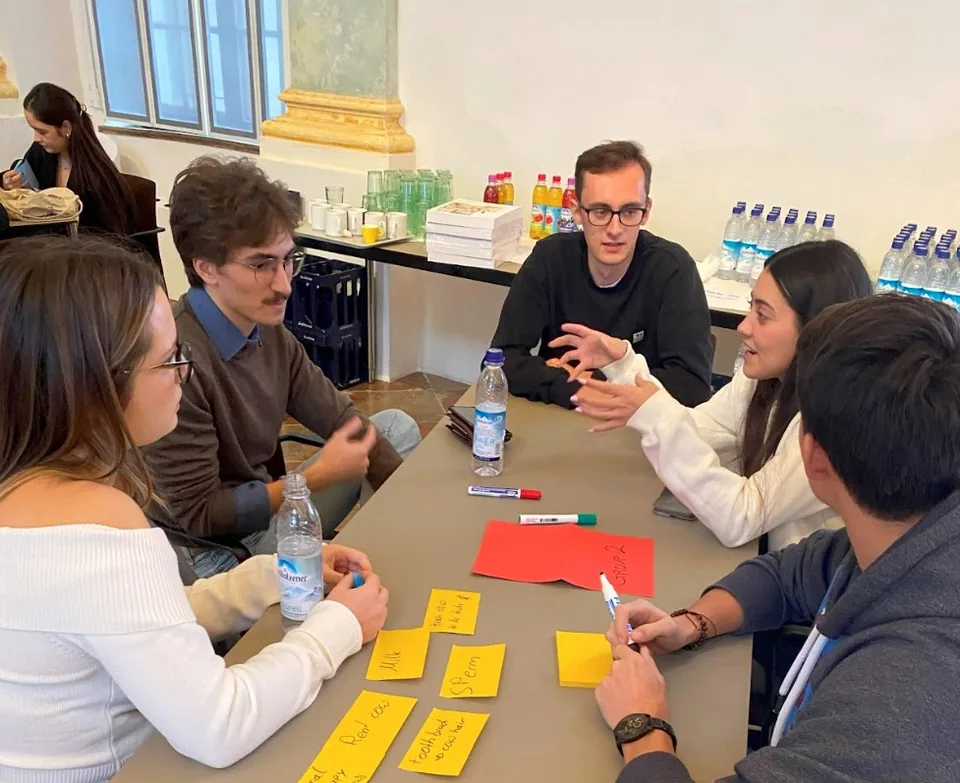 Enactus Munich members discussing ideas around a table with sticky notes