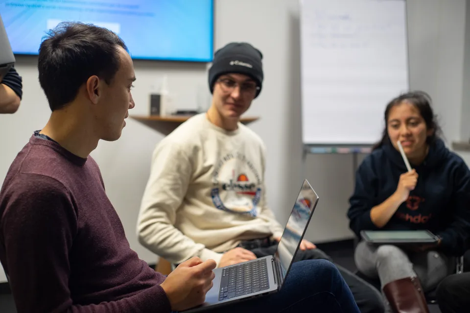 Enactus Munich members discussing their work with an open laptop in a team session